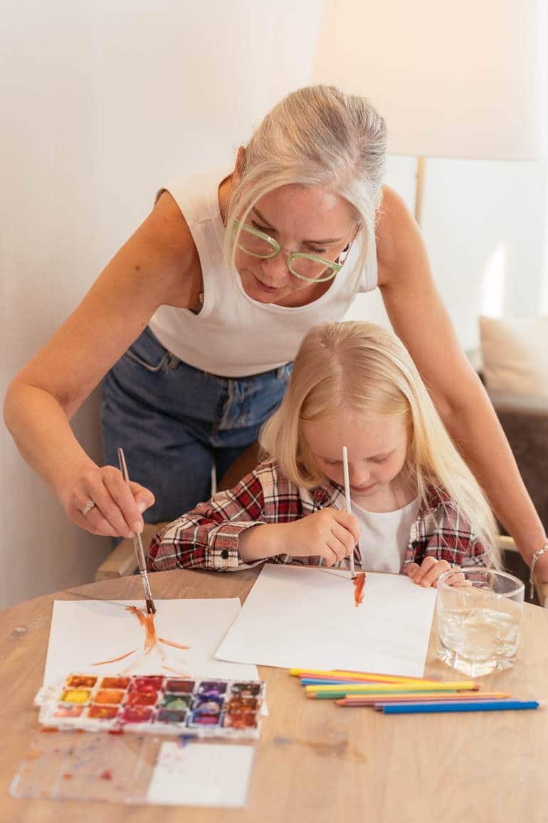 Criança e adulta pintando