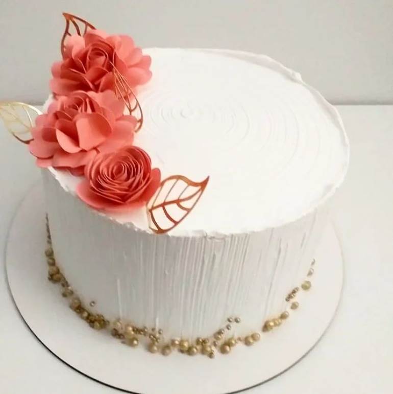 Bolo branco com enfeite rosa queimado