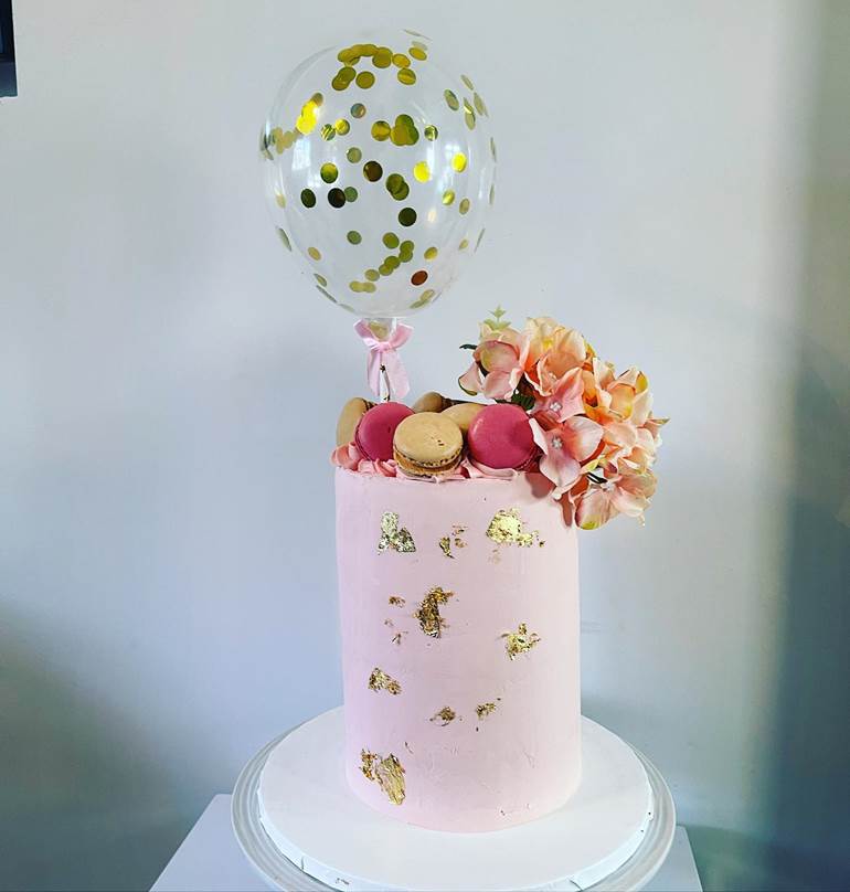 Bolo com balão, flores e macarons