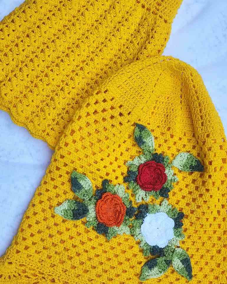 Capa de crochê amarelo com flores