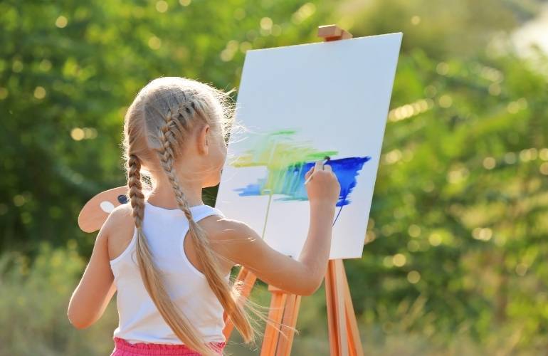 Criança da educação infantil pintando primavera