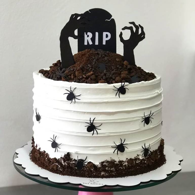 Bolo de zumbi saindo da terra com aranhas