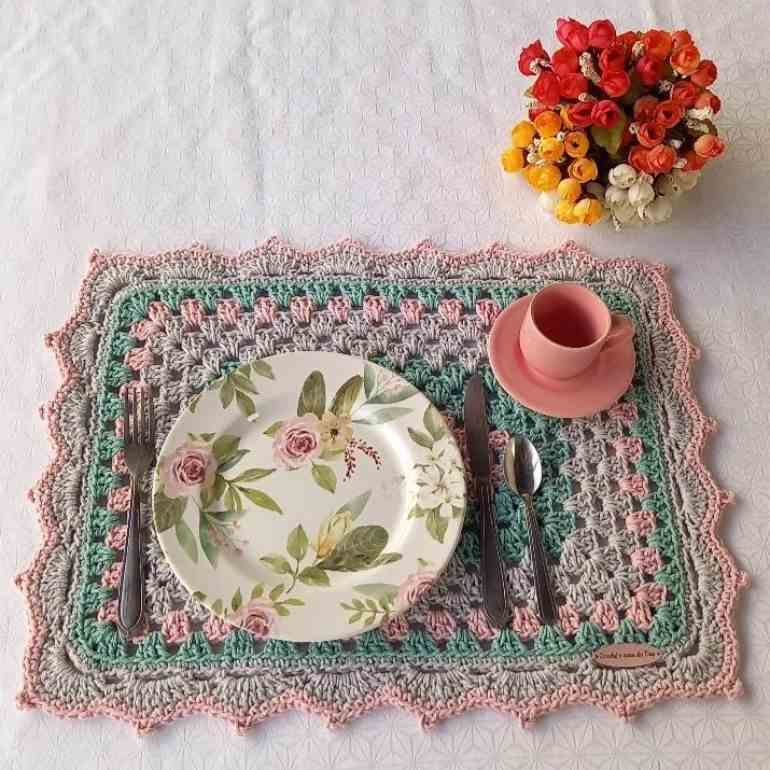 Sousplat de crochê em tons pastéis com flores e prato decorado