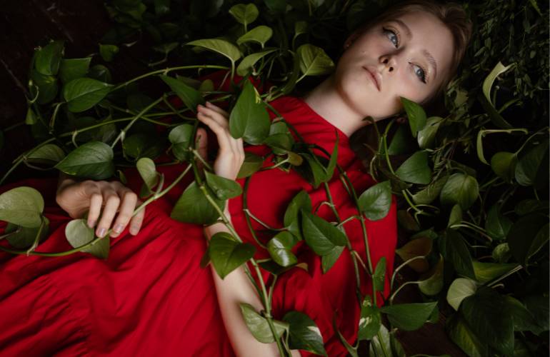 Mulher com vestido vermelho com planta de folha verde