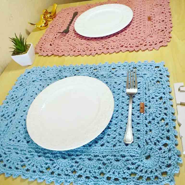 Sousplats de crochê rosa e azul com pratos brancos