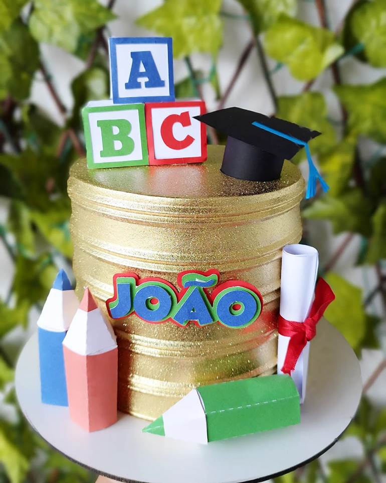 Bolo dourado ABC com lápis e diploma