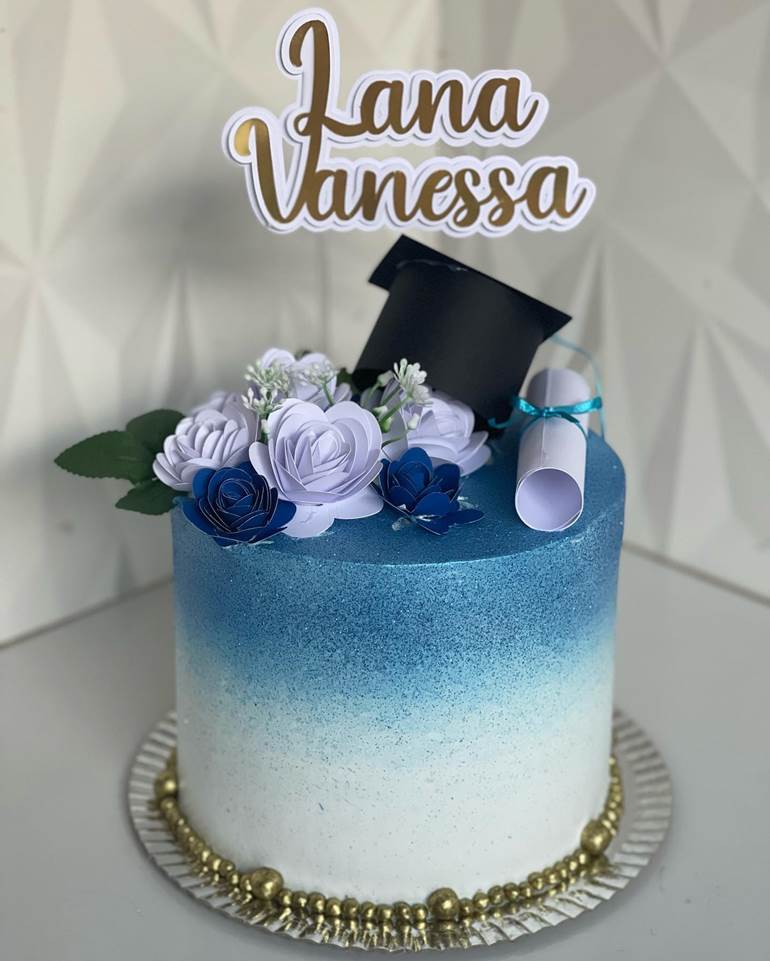 Bolo degradê azul com glitter no topo, flores e diploma