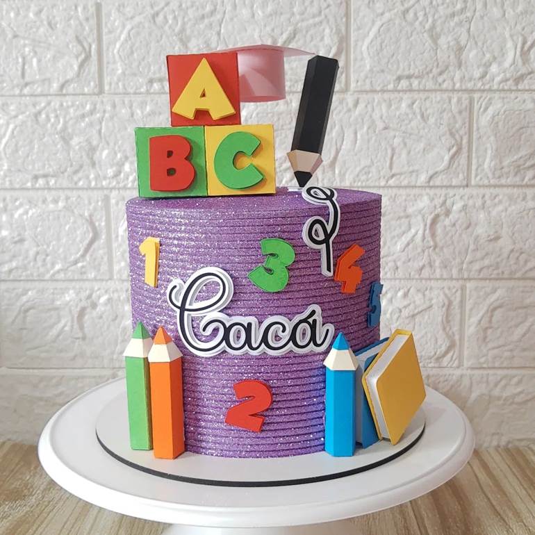 Bolo lilás com glitter ABC, lápis e caderno