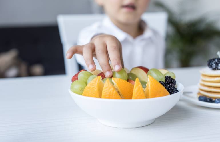 Criança comendo fruta saudável 