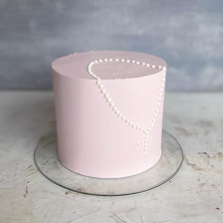 Bolo rosa pastel com terço branco