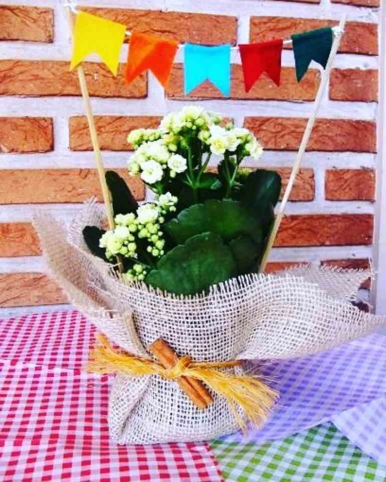 Centro de mesa com flores brancas e bandeirinha
