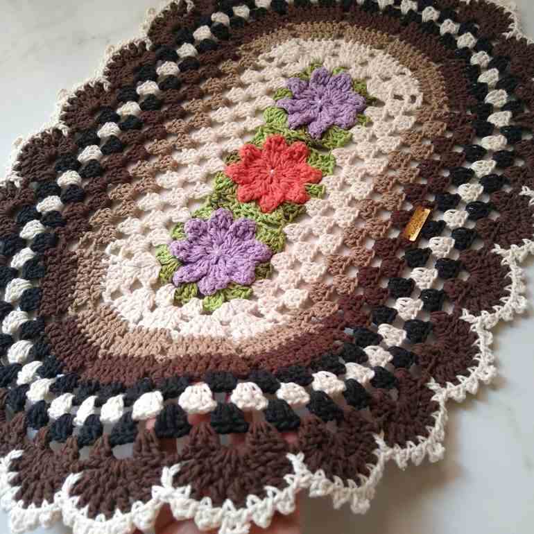 Tapete de crochê marrom e flores coloridas