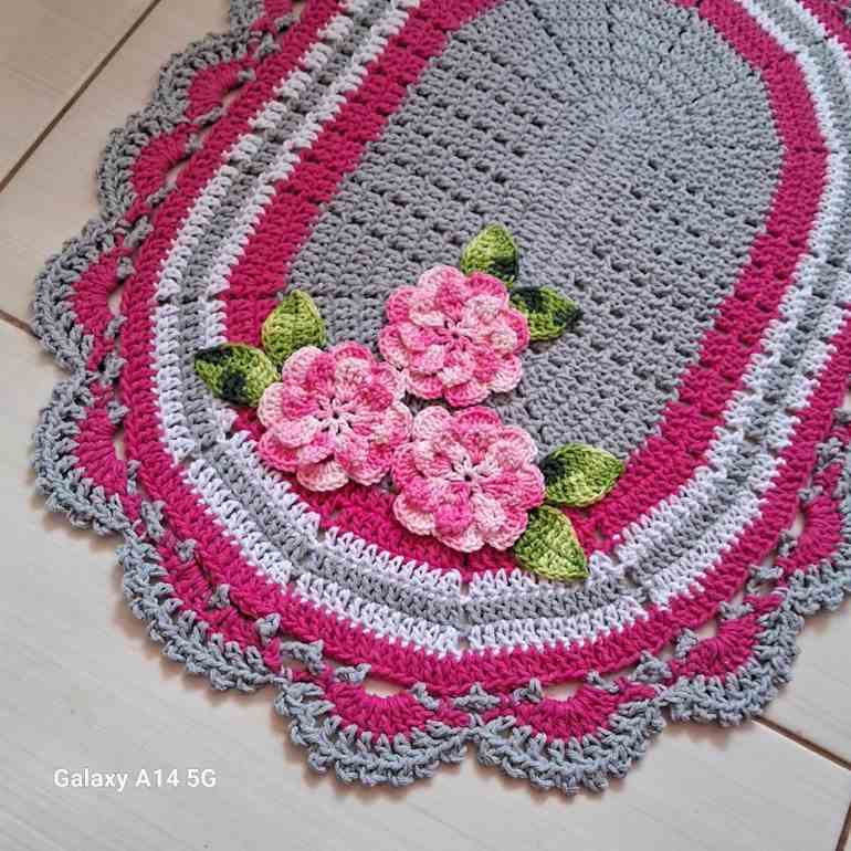 Tapete de crochê cinza com flor rosa
