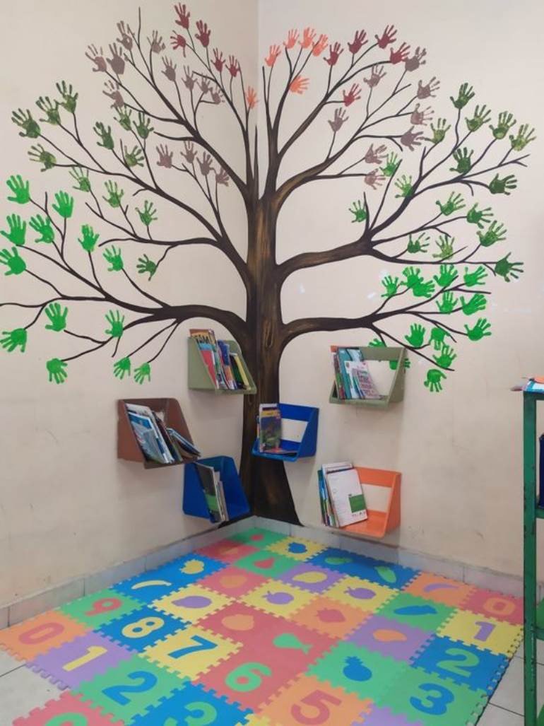 Decoração com árvore de mãos e livros